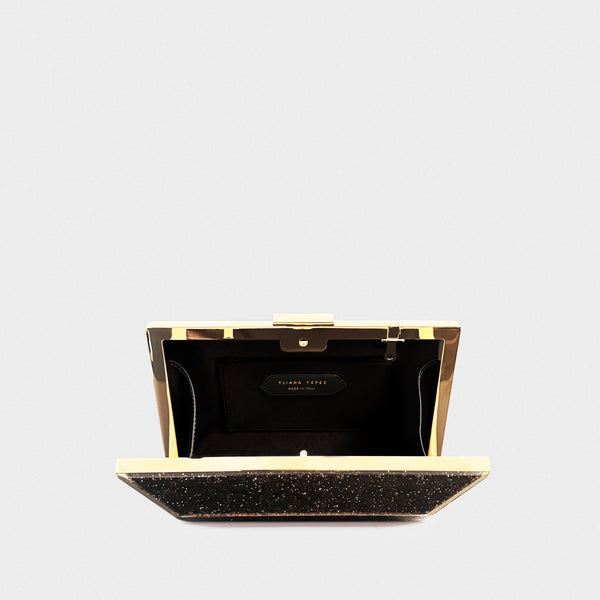 YLIANA YEPEZ minaudire Black glittery clutch bag with gold accents on a light gray background