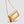 A metallic gold crocodile-embossed leather clutch bag with a matching gold chain strap, shown against a solid light gray background.