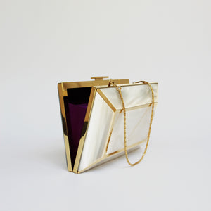 YLIANA YEPEZ Minaudiere. Rectangular clutch with gold frame and beige interior on a white background