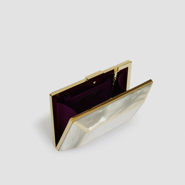YLIANA YEPEZ Minaudiere. Rectangular clutch with gold frame and beige interior on a white background