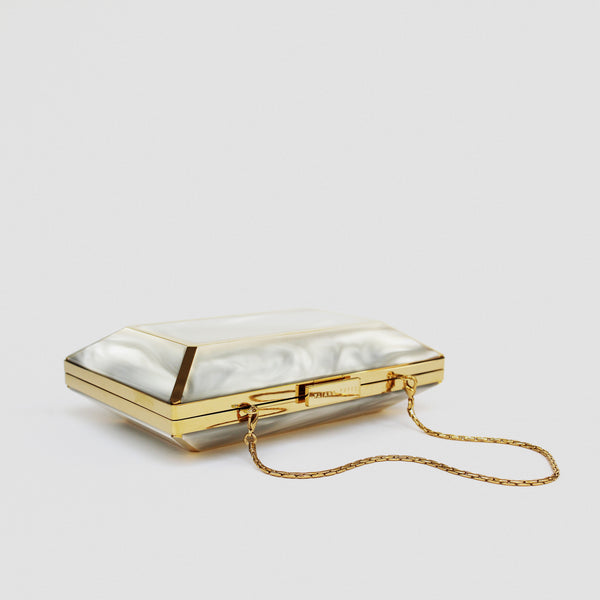 YLIANA YEPEZ Minaudiere. Rectangular clutch with gold frame and beige interior on a white background
